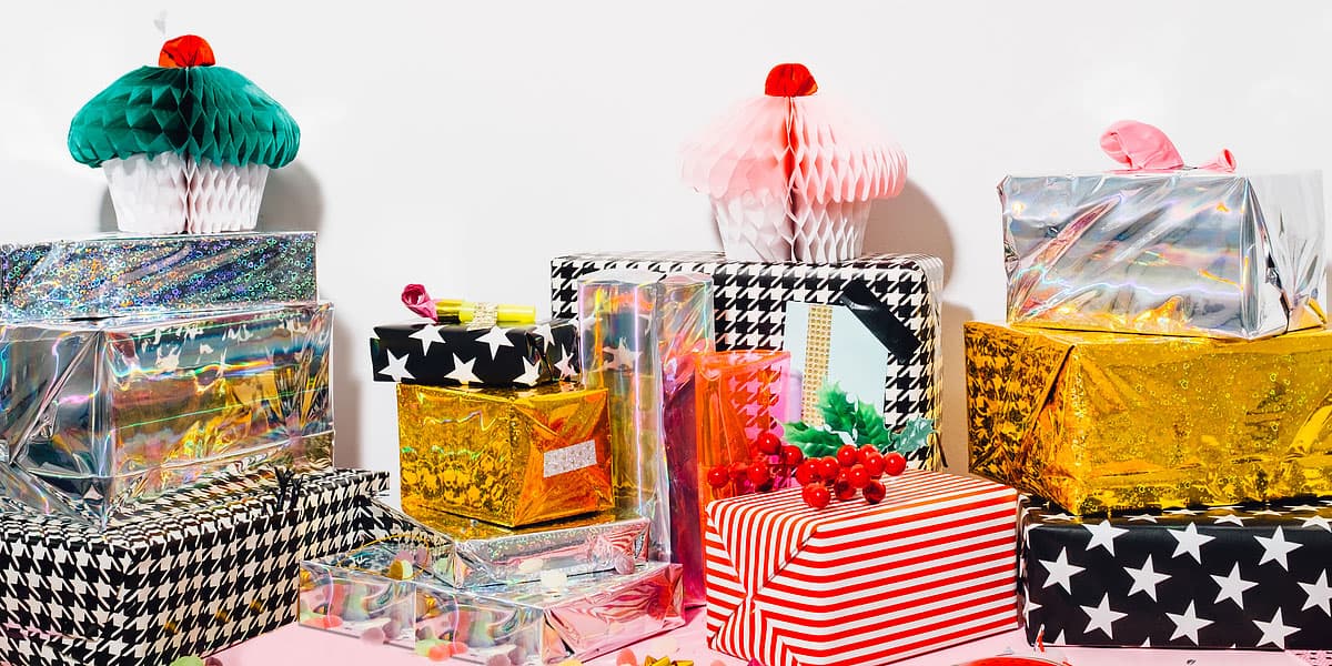 Colorfully wrapped Secret Santa gifts piled under a Christmas tree