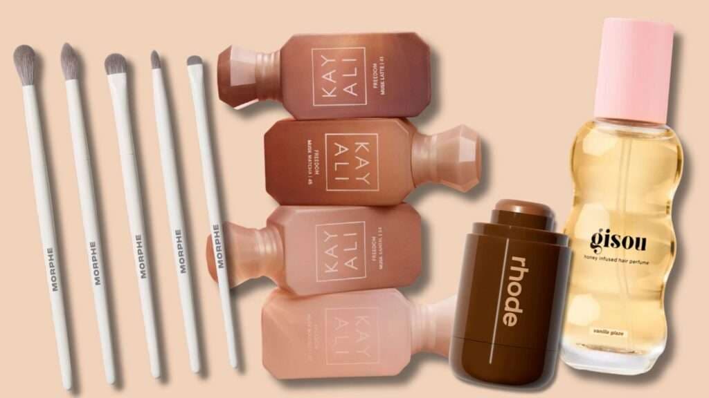 Flat lay of fall beauty gifts: eye brushes, mini perfume set, cream bronzer, and hair perfume