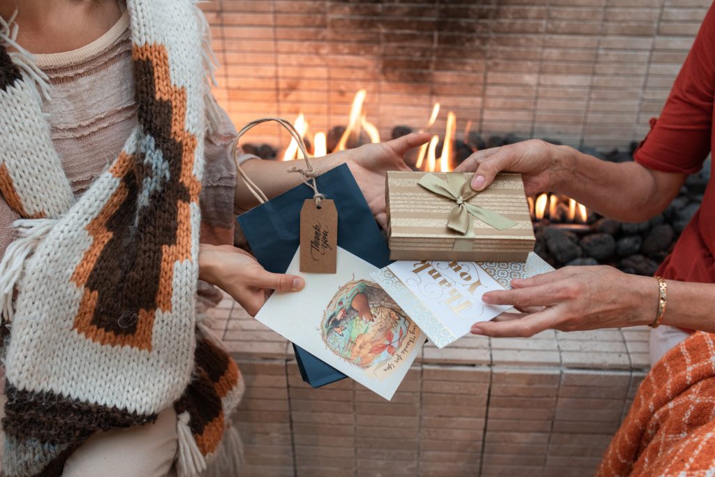 Women exchanging gifts of gratitude for Friendsgiving