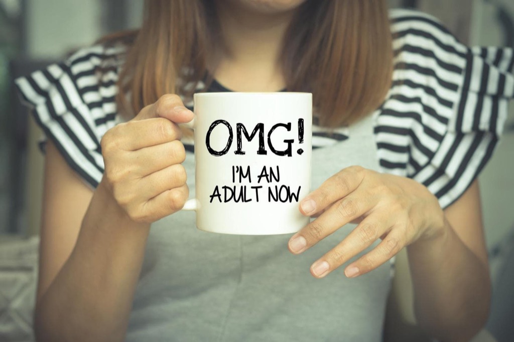 A woman holding a mug that reads OMG I'm an Adult Now
