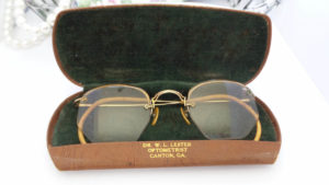 Vintage gold wire-rim eyeglasses resting open in their case