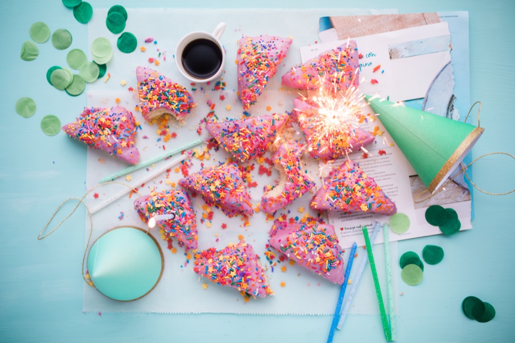 A lifestyle flat lay with coffee, sprinkle-covered pastries, and party confetti