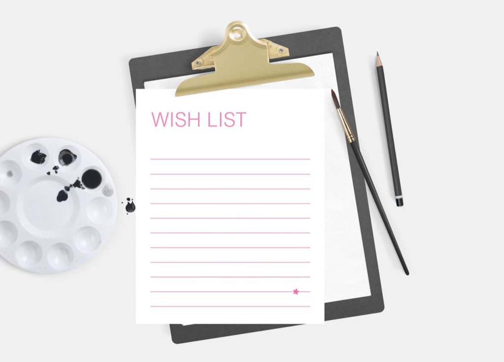 A blank wish list on a clipboard next to paint and a paintbrush